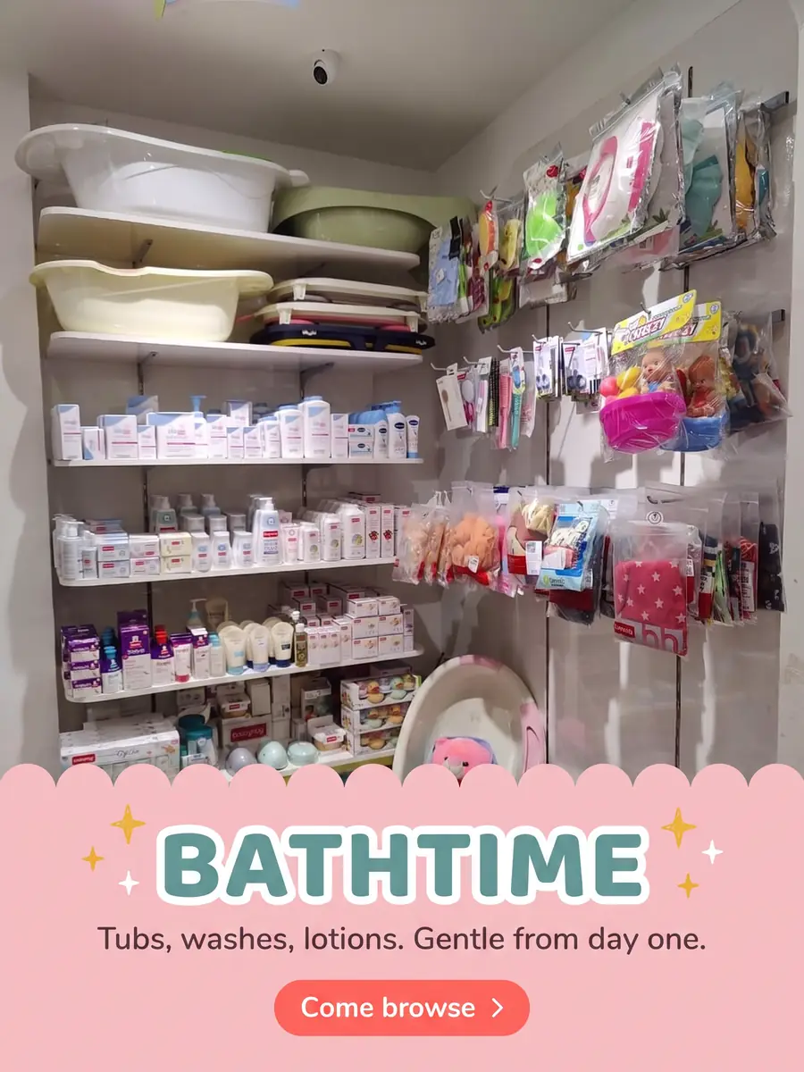 The bath and skincare corner with baby tubs, washes, lotions and a doll in a pink bouncer. Text on the photo: Bathtime — tubs, washes, lotions, gentle from day one. Come browse.
