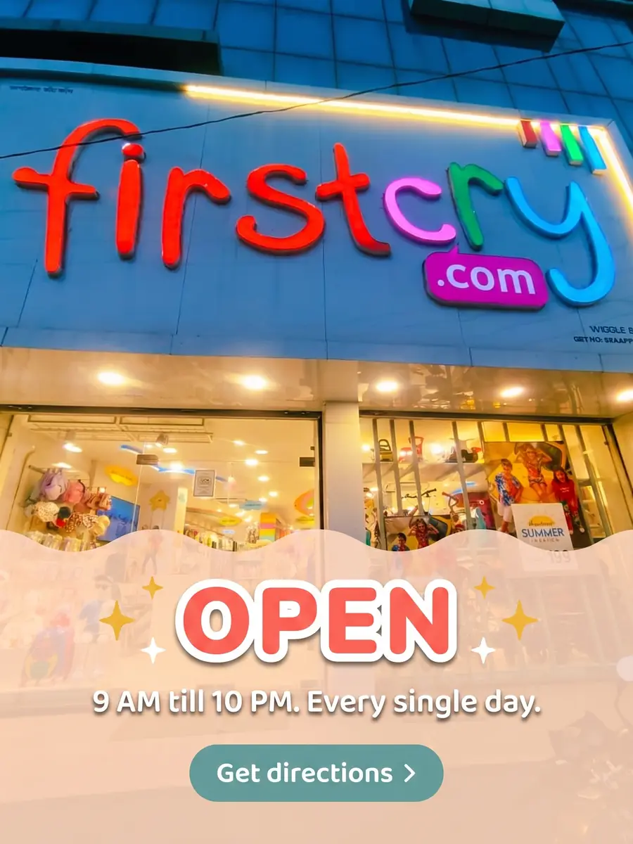 The lit-up firstcry.com storefront in Etawah at dusk, with prams, soft toys and summer fashion visible through the glass. Text on the photo: Open — 9 AM till 10 PM, every single day. Get directions.